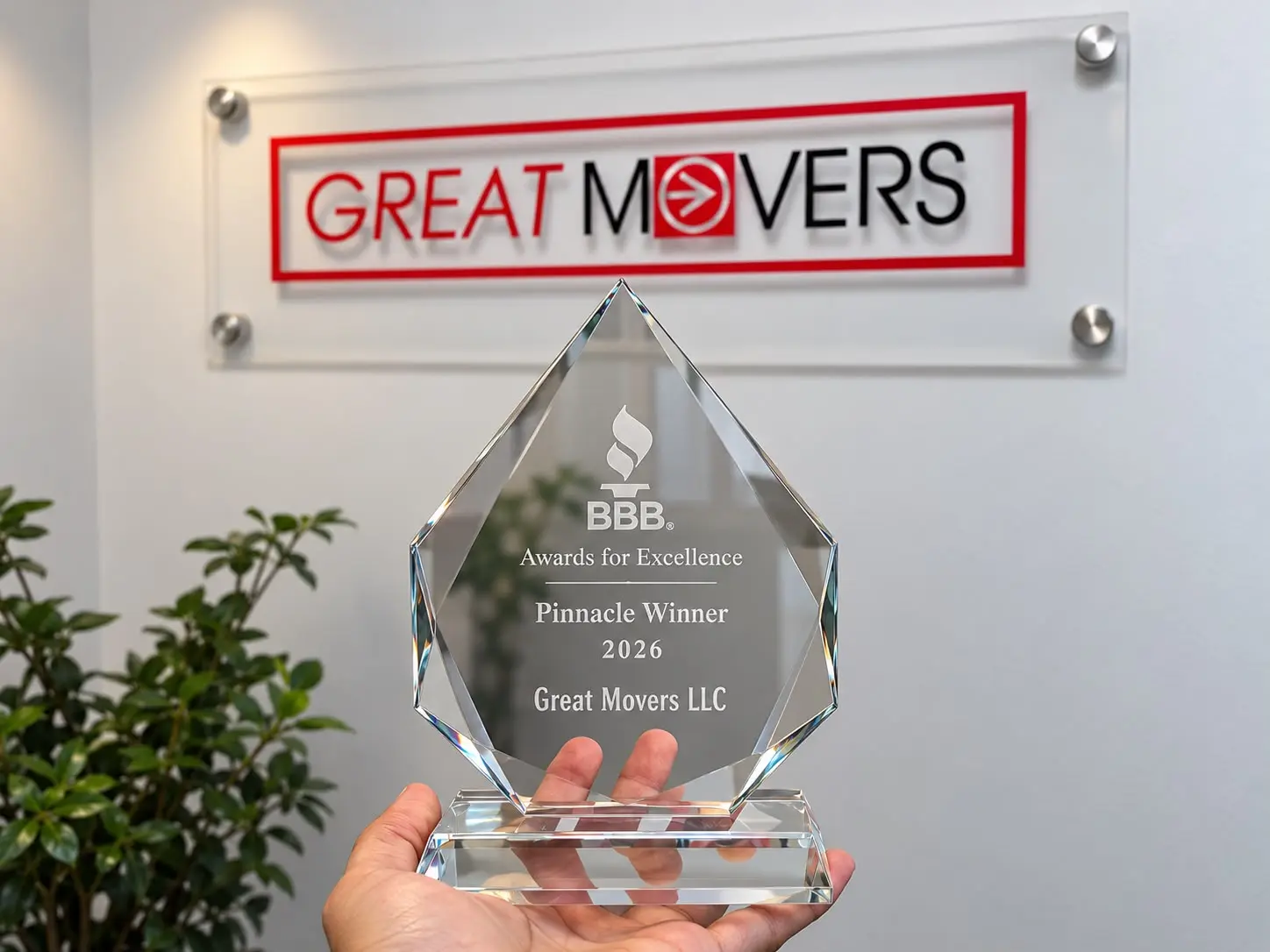 2026 BBB Awards for Excellence Pinnacle Winner trophy for Great Movers LLC in front of the company sign